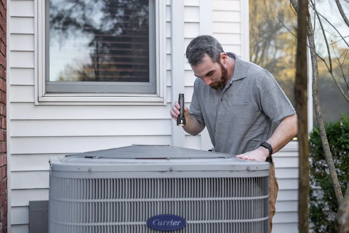 HVAC technician inspecting unit